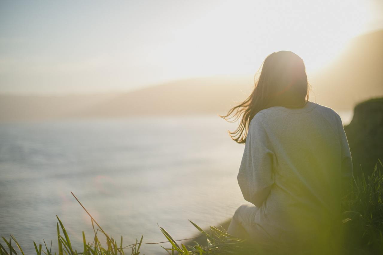 Sophrologie : pour qui, quand et pour quel accompagnement, femme de dos assise face à la nature